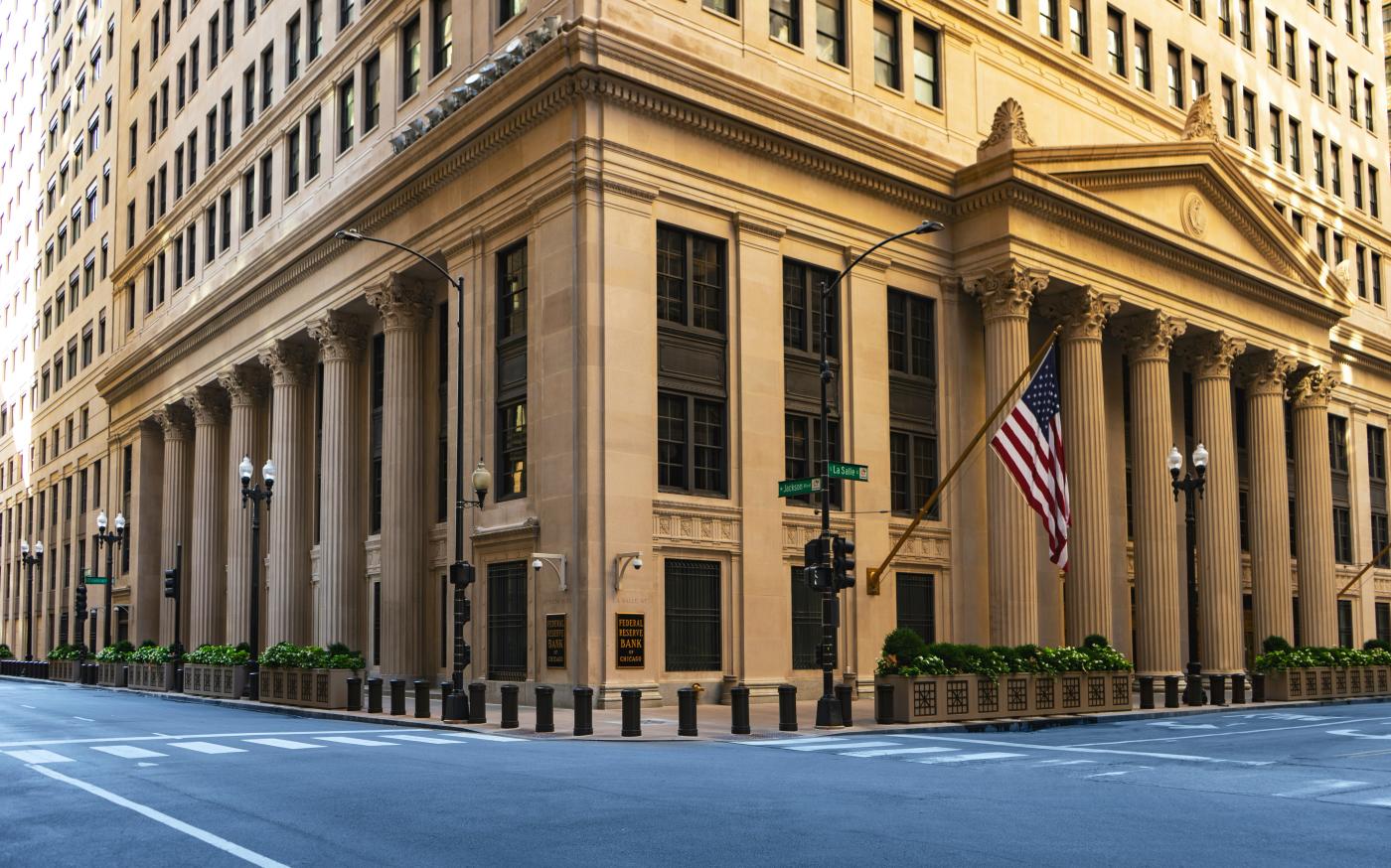 a large building with columns and a flag on the corner by Joshua Woroniecki courtesy of Unsplash.