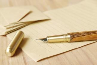 a pen and some papers on a table by Towfiqu barbhuiya courtesy of Unsplash.