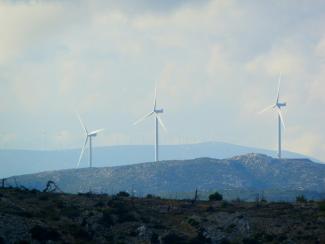 white wind turbines on green grass field during daytime by Feri & Tasos courtesy of Unsplash.