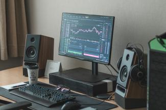 black flat screen computer monitor turned on beside black computer keyboard by Behnam Norouzi courtesy of Unsplash.