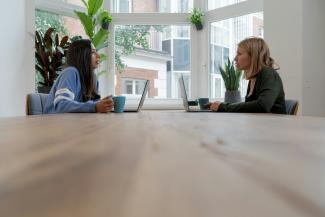 woman in blue long sleeve shirt sitting beside woman in black long sleeve shirt by airfocus courtesy of Unsplash.