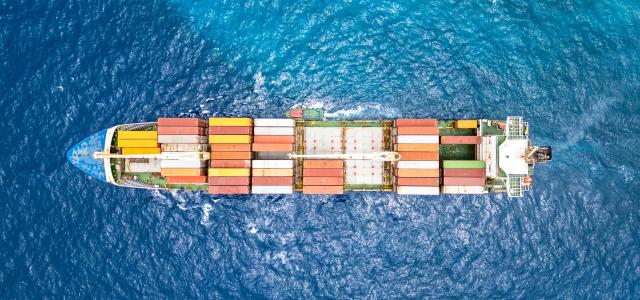 An aerial view of a cargo ship in the ocean by Bent Van Aeken courtesy of Unsplash.