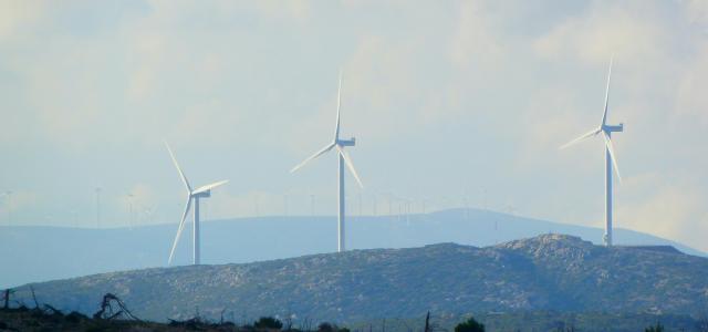 white wind turbines on green grass field during daytime by Feri & Tasos courtesy of Unsplash.